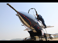 A ground crew member exams a J-10 jet fighter in Tianjin, east China, Nov. 5, 2010. [Xinhua]