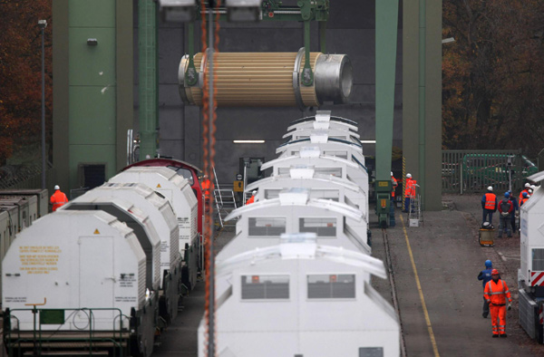 A Castor nuclear waste container is loaded from a train onto a special flat bed truck at the embarking station in Dannenberg Nov 8, 2010. The controversial shipment of eleven Castor containers with spent German nuclear fuel arrived in Dannenberg on Monday and will be loaded onto trucks before transportation to the nearby Gorleben intermediate storage facility in northern Germany after it left the French reprocessing plant of La Hague on Friday by train. [China Daily/Agencies]