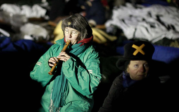 An anti-nuclear protester plays her flute as demonstrators block the main road to Germany&apos;s interim nuclear waste storage facility in the northern German village of Gorleben, Nov 8, 2010. [China Daily/Agencies]