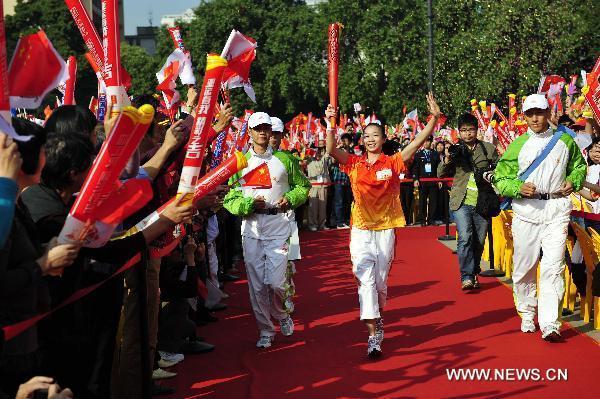 Torchbearer Yang Yilin runs with the torch during the torch relay for the 16th Asian Games in Guangzhou, south China's Guangdong Province, Nov. 9, 2010. (Xinhua/Liang Xu)