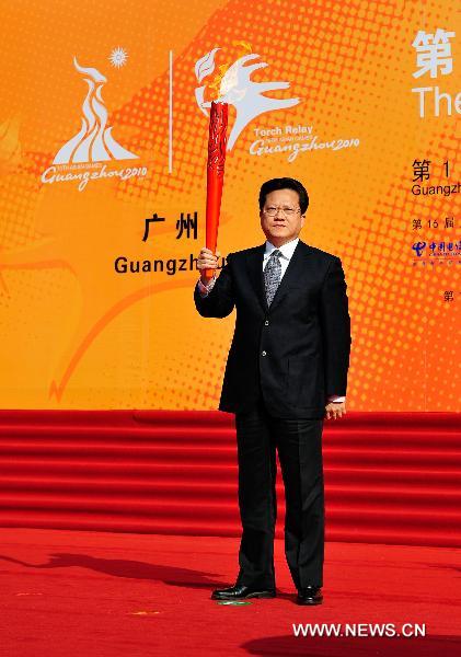 Zhang Guangning, Guangzhou City Party Secretary, holds the torch before the torch relay for the 16th Asian Games in front of Sun Yat-sen Memorial Hall in Guangzhou, south China's Guangdong Province, Nov. 9, 2010. (Xinhua/Liang Xu)