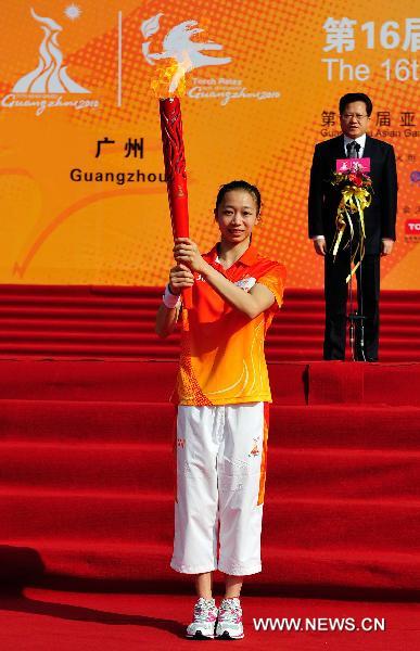 Torchbearer Yang Yilin holds the torch before the torch relay for the 16th Asian Games in Guangzhou, south China's Guangdong Province, Nov. 9, 2010. (Xinhua/Liang Xu) 