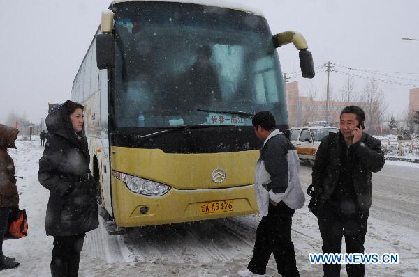 Delayed coach passengers wait for other transportation at the Yingchengzi toll station on the Changchun-Liaoyuan Highway in northeast China's Jilin Province. Traffic control measures have been taken in parts of Jilin's provincial highway system after heavy snowfall hit most parts of Jilin since Sunday evening. 