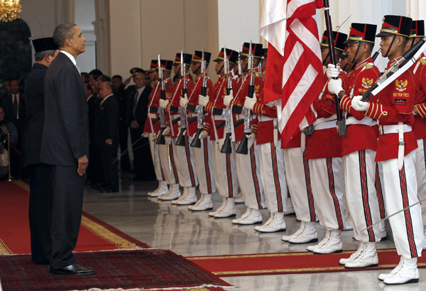 US President Barack Obama, accompanied by his Indonesian counterpart Susilo Bambang Yudhoyono, listens to the national anthem during a welcoming ceremony at Merdeka Palace in Jakarta Nov 9, 2010. [China Daily/Agencies]