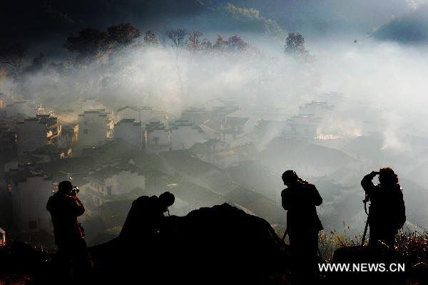 Tourists take pictures of the scenery at Chengcun Village of Dazhangshan Township in Wuyuan County, east China&apos;s Jiangxi Province, Nov. 9, 2010. [Xinhua] 