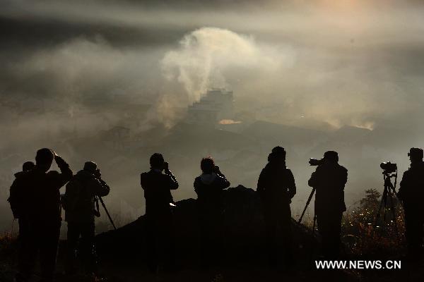 Tourists take pictures of the scenery at Chengcun Village of Dazhangshan Township in Wuyuan County, east China&apos;s Jiangxi Province, Nov. 9, 2010. [Xinhua] 