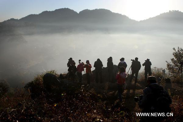 Tourists take pictures of the scenery at Chengcun Village of Dazhangshan Township in Wuyuan County, east China&apos;s Jiangxi Province, Nov. 9, 2010. [Xinhua] 