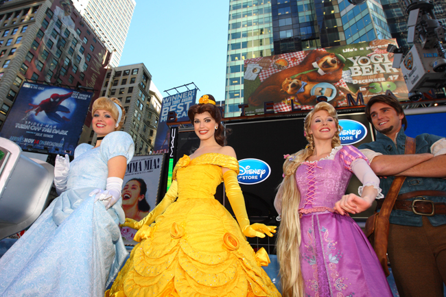 Cinderella (L) and other Disney characters pose during the opening ceremony of the new Time Square Disney Store, the largest in North America, Nov 9, 2010. [Xinhua]