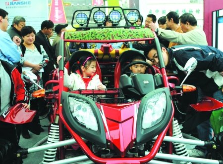 People visit a latest motorcycle model at the Chongqing low-carbon patent exhibition.