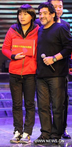 Argentine soccer legend Diego Maradona (R) poses for picture with a fan at a charity activity in Hefei, capital of east China's Anhui Province, on Nov. 9, 2010. [Xinhua/Guo Chen]