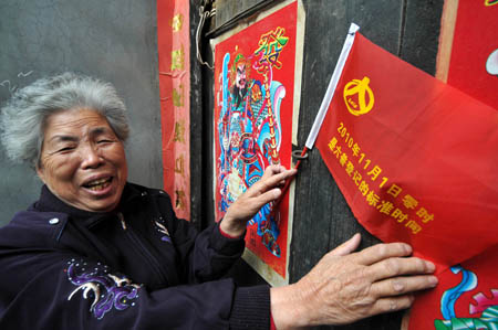 Wang Guirong, 76, flies a red flag to show her support for the first day of the census on November 1 in the Yuyuan neighborhood complex, Qiaodong district of Xingtai, a prefecture-level city in southern Hebei Province. 