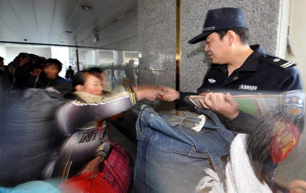 A staff member checks the ticket for a migrant cotton picker at the Urumqi South Railway Station in Urumqi, capital of Northwest China&apos;s Xinjiang Uygur autonomous region, Nov 10, 2010. [Xinhua]