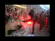 Students demonstrating against higher tuition fees burned placards, scuffled with riot police and smashed windows at the headquarters of Britain's governing Conservative party on Wednesday. [sohu.com]