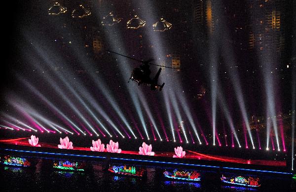 Picture taken on Nov. 10, 2010 shows a helicopter flying over the illuminated Zhujiang River in Guangzhou, south China&apos;s Guangdong Province. The 16th Asian Games would run in Guangzhou from Nov. 12 to 27. [Xinhua] 