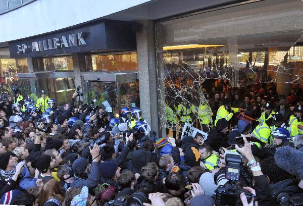 Police and demonstrators confront each other in the foyer of the Conservative Party headquarters building during a protest in central London November 10, 2010. Students demonstrating against higher tuition fees burned placards, scuffled with riot police and smashed windows at the headquarters of Britain's governing Conservative party on Wednesday. [Xinhua]
