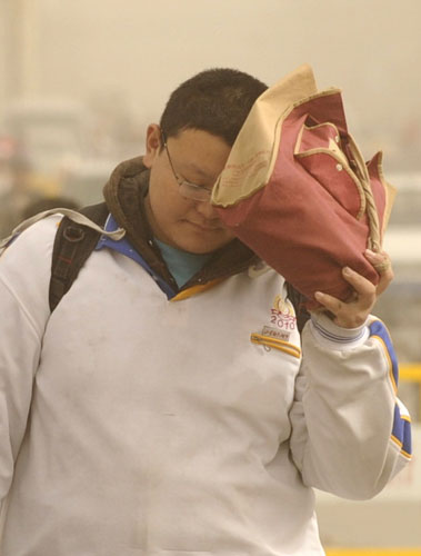 A student walks against the wind as a sand storm hit Jinan, capital of East China&apos;s Shandong province, Nov 11, 2010. [Xinhua]