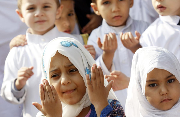 Pupils pray near a scale model of the Kaaba which was constructed at Nile Garden school before the upcoming Eid Al-Adha festival in Cairo Nov 11, 2010. [China Daily/Agencies] 