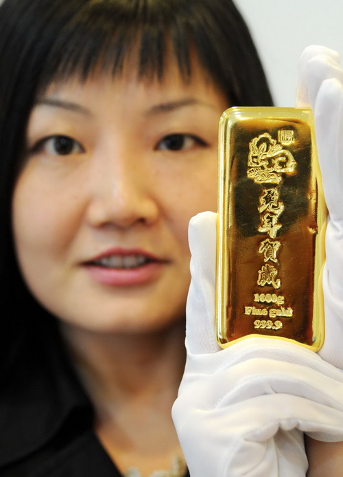 A jewelry staffer displays a 1000g Year-of-Rabbit gold bar at a jowelry store in Suzhou, East of China&apos;s Jiangsu province on Nov 11,2010. To seize the market share, many jewlry stores start to sell new designs for the upcoming 2011, the Year of the Rabbit in Chinese lunar calendar.[Xinhua]