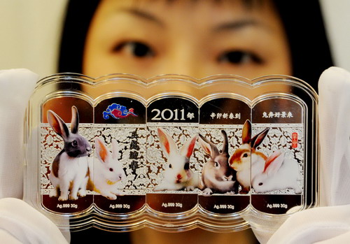 A jewelry staffer displays silver bullions embedded with colored rabbits at a jewelry store in Suzhou, East China&apos;s Jiangsu province on Nov 11,2010. To maximize profits, many jewelry stores have begun to sell new designs for 2011, the Year of the Rabbit in the Chinese lunar calendar.[Xinhua]