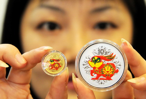 A jewelry staffer shows a pair of golden and silver commemorative coins embedded with colored rabbits at a jewelry store of Suzhou, East of China&apos;s Jiangsu province, on Nov 11, 2010. To maximize profits, many jewelry stores have begun to sell new designs for 2011, the Year of the Rabbit in the Chinese lunar calendar.[Xinhua]