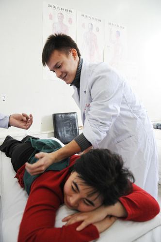 Maksim, from Russia, gives a massage to a patient during his clinical practice in Harbin, the capital of Northeast China&apos;s Heilongjiang province, Nov 9, 2010. 