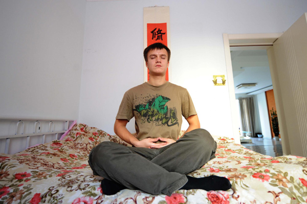 Maksim practices qigong, Chinese breathing exercises, in his dorm, Nov 9, 2010. [Xinhua]