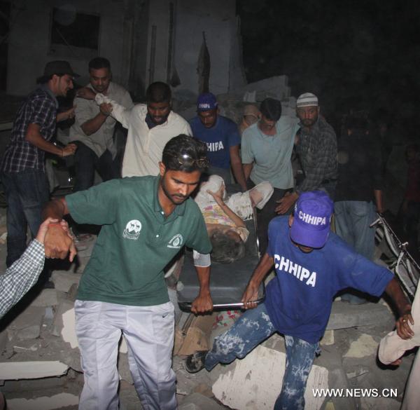 People transfer an injured woman from the blast site in southern Pakistan&apos;s Karachi on Nov. 11, 2010. At least 30 people including 12 policemen were killed and 150 others injured in a powerful blast that went off Thursday night in the downtown area of Karachi, the largest industrial city in southern Pakistan. [Xinhua]