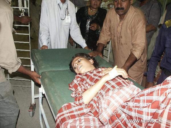 People transfer a woman injured in a blast to hospital in southern Pakistani port city of Karachi on Nov. 11, 2010. At least 30 people were killed and 150 others injured in a powerful blast that went off Thursday night in the downtown area of Karachi, the largest industrial city in southern Pakistan. [Toheed/Xinhua]