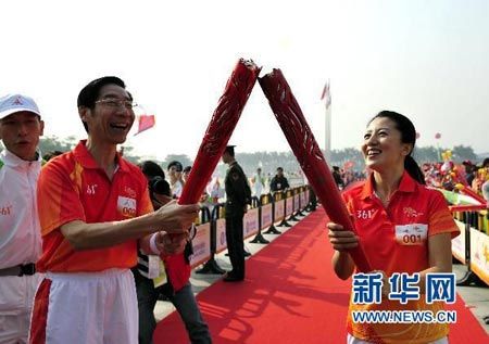 Yang Yang(R), the first torchbearer in relay hands over the torch with No.2 torchbearer Feng Jianzhong(L).  