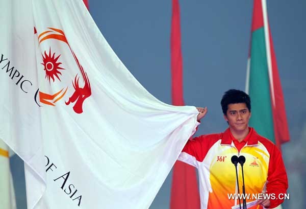 Chinese badminton world champion Fu Haifeng takes oath on behalf of all athletes during the opening ceremony of the 16th Asian Games at the Haixinsha Island in Guangzhou, China, Nov. 12, 2010.(Xinhua/Fan Jun)