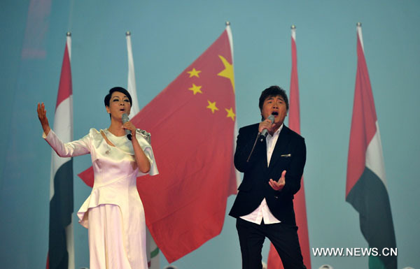 Chinese singer Sun Nan (R) and Mao Amin sing the anthem 'Here We Meet Again' during the art performance of opening ceremony at the 16th Asian Games at the Haixinsha Island in Guangzhou, China, Nov. 12, 2010. (Xinhua/Liu Dawei)