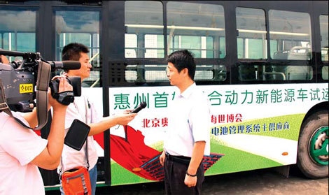 Liu Fei (right), president of Huizhou Epower Electronics Co Ltd, at a recent interview with a local TV station during a test drive of the first new energy bus using Epower's system. [China Daily] 