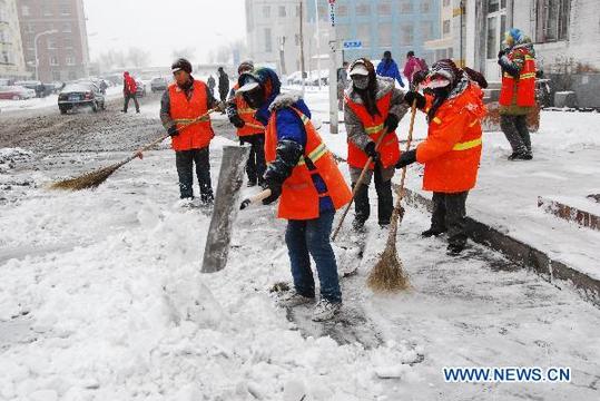 Cleaners sweep snow on a street in Harbin, capital of northeast China's Heilongjiang Province, Nov. 12, 2010. A heavy snow hit the city from late Thursday. [Xinhua] 