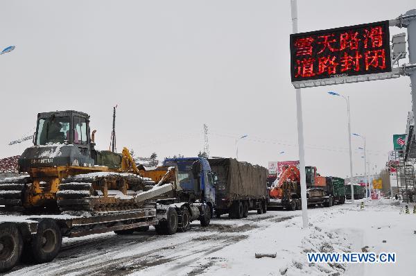 Vehicles are stranded at the entrance of the Harbin-Mudanjiang highway in northeast China's Heilongjiang Province, Nov. 12, 2010. The highway, shut down due to the heavy snow from late Thursday, was reopened to small vehicles at the noon of Friday. The provincial meteorologicial department issued a blue warning signal of snow on late Thursday. 