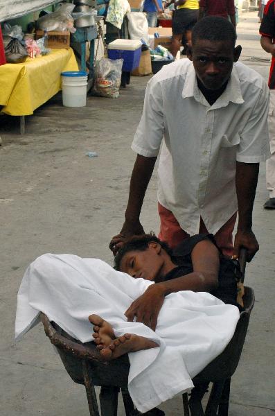 A Haitian resident suffering from cholera is transported to receive treatment at St-Catherine hospital in the slum of Cite-Soleil in Port-au-Prince November 12, 2010. [Xinhua/Reuters Photo]