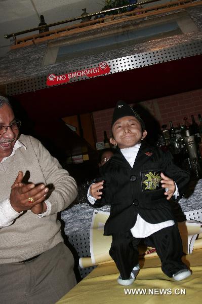 Nepalese world's shortest man Khagendra Thapamagar (R) attends a promotion of Nepalese tourism in London, capital of Britain, Nov. 11, 2010. Measuring 67.08 cm tall and 5.5 kilograms in weight, 18-year old Khagendra Thapamagar has been confirmed by the Guiness World Records to be the world's shortest adult man this year. 