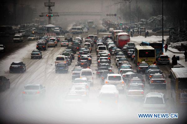 Vehicles are seen on snow-covered roads in Harbin, capital of northeast China's Heilongjiang Province, Nov. 13, 2010. A new round of heavy snowfall hit Harbin on Friday, seriously affecting local residents' everyday life. [Wang Jianwei/Xinhua]