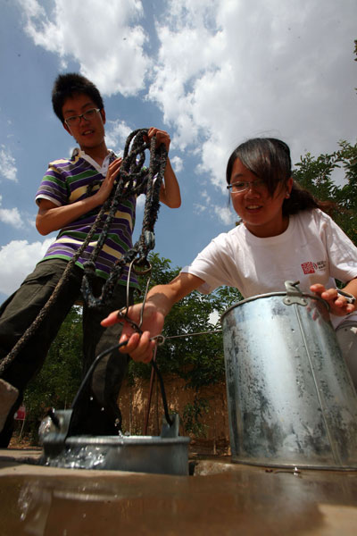 Volunteers carry water from a cistern.
