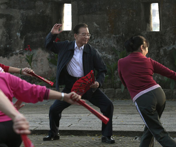 Chinese Premier Wen Jiabao practises tai chi with local residents at a park in Macao Nov 14, 2010. Wen is on a two-day visit to take part in the opening ceremony of the third Ministerial Conference of the Forum for Economic and Trade Cooperation between China and Portuguese-speaking Countries. [China Daily/Agencies] 