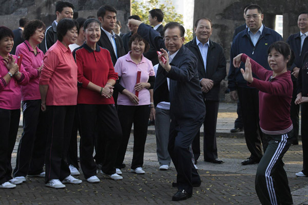 Chinese Premier Wen Jiabao (C) practises tai chi with local residents at a park in Macao Nov 14, 2010. [China Daily/Agencies] 