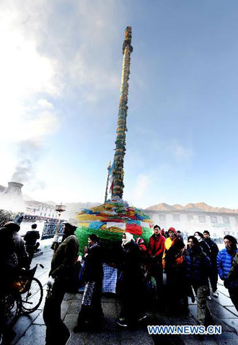 Lamaist pilgrims worship by circling a sacred mast decorated with prayer flags and banners in central Lhasa&apos;s Jokhang Temple, Southwest China&apos;s Tibet autonomous region, Nov 14, 2010. Over the past few days, Lamaism believers in the Tibet and Tibetan areas of Qinghai, Gansu, Sichuan and Yunan provinces have been travelling on a winter pilgrimage to Lhasa, Shigatse and Tsedang. [Xinhua]