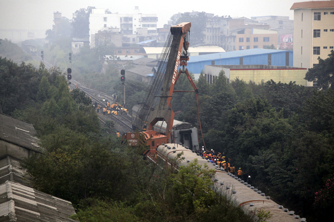 Maintenance workers operate machine to remove the derailed train coach at Liuzhou South Station in Liuzhou City, south China&apos;s Guangxi Zhuang Autonomous Region, Nov. 15, 2010. The fifth coach of the K157 passenger train heading to Zhanjiang City of Guangdong Province from Beijing derailed upon arriving at the Liuzhou South Station at about 3 a.m. Monday. No casualties have been reported, and the investigation of the accident is underway. [Xinhua]