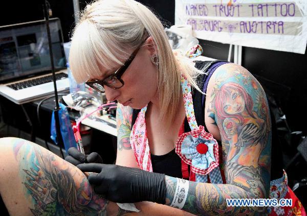 A tattoo artist tattoos for a guest during the first Brussels international tattoo expo in Brussels, Nov. 13, 2010. [Xinhua] 