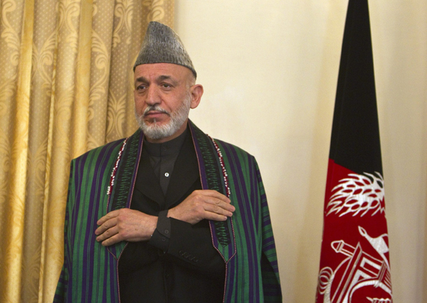 Afghan President Hamid Karzai adjusts his coat during a news conference in Kabul October 25, 2010. [Xinhua]