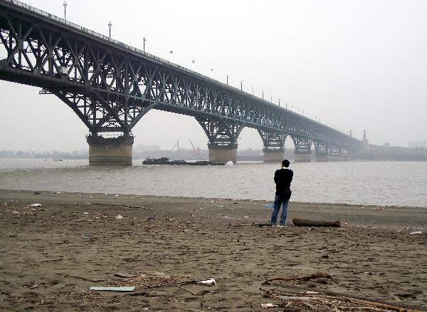 A man stands on riverbed of Nanjing section of the Yangtze River in Nanjing, capital of east China&apos;s Jiangsu Province, Nov. 14, 2010. Water level of Nanjing section of the Yangtze River has dropped to 4.08 meters till 5:00 p.m. Sunday, due to dwindling water supply from the upper reaches recently. [Xinhua] 