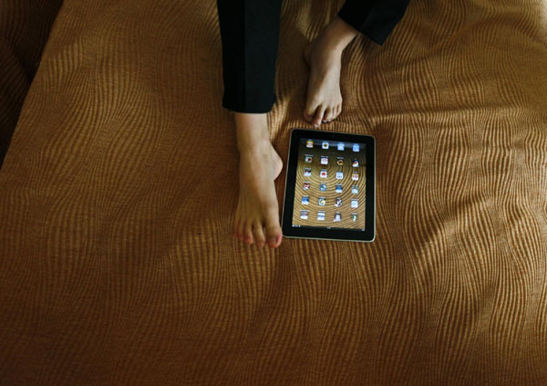 Pianist Liu Wei who is armless, plays with an iPad with his toes before a promotional event for a local television channel, in his hotel room in Beijing, Nov 15, 2010. [China Daily/Agencies] 