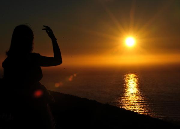 A tourist enjoys the view of sunset on the Signal Hill in Cape Town, South Africa, on Nov. 14, 2010. [Xinhua] 