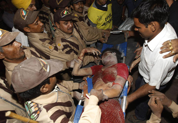 A rescue worker carries an injured girl at the site of a building collapse in New Delhi November 16, 2010. A residential building collapsed in Lalita Park in New Delhi&apos;s Laxmi Nagar area on Monday evening. [China Daily/Agencies]