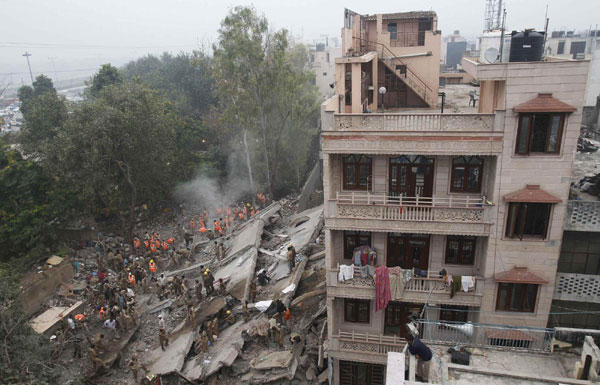 Rescue workers search for survivors under the rubble of a collapsed building in New Delhi November 16, 2010. [China Daily/Agencies]