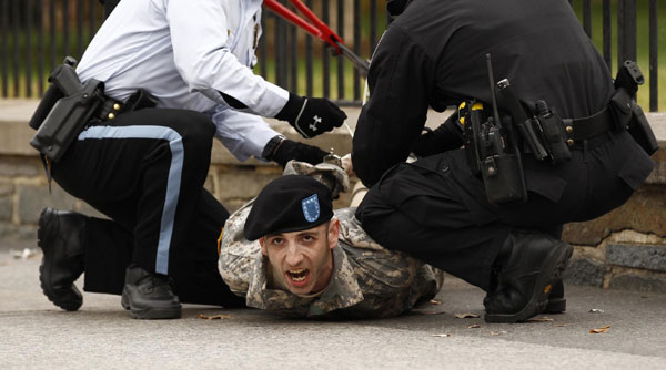 Former Army soldier Ian Finkenbinder is arrested after handcuffing himself to a fence at the White House in Washington November 15, 2010. Finkenbinder and twelve others were arrested in their protest against the &apos;Don&apos;t Ask, Don&apos;t Tell&apos; law that prevents openly gay men and women from serving in the US military. [China Daily/Agencies] 